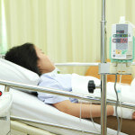 Patient in hospital bed with medical infusion drip tool